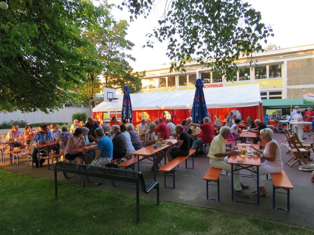 Menschen an Biertischen auf Dorffest