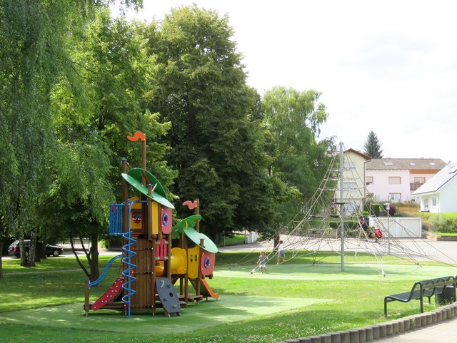 Spielplatz an der Grundschule mit Klettergerüst im Grünen