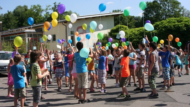 Kinder mit Luftballons auf dem Schulhof